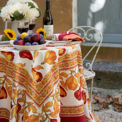 Decorative tablecloth with autumnal design on a table set outdoors.