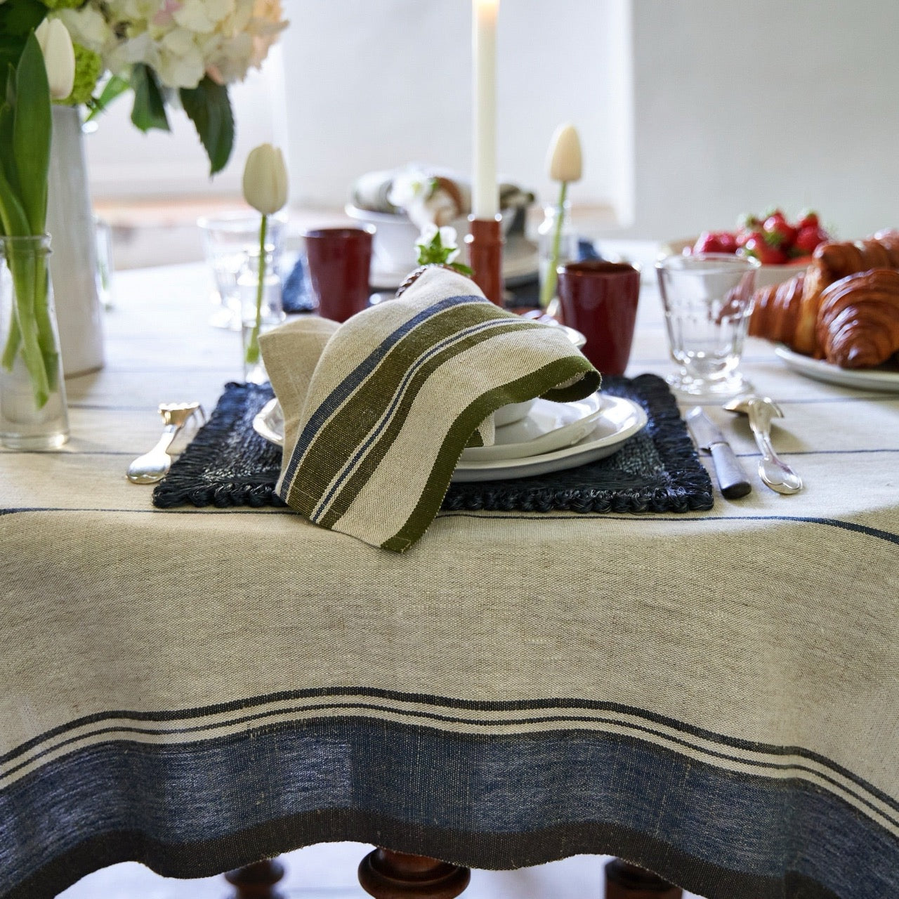 Dining table setting with a striped napkin, plates, and cutlery.