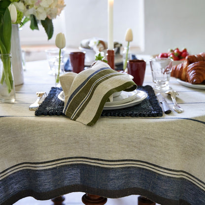 Dining table setting with a striped napkin, plates, and cutlery.