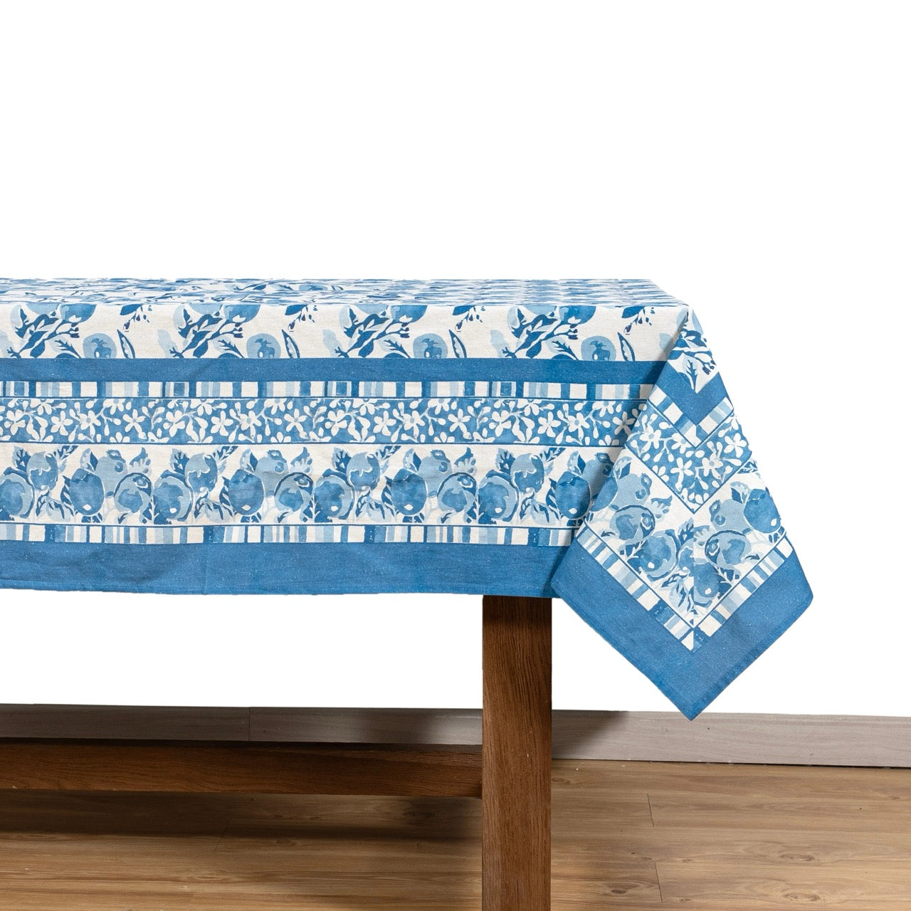 Blue and white patterned tablecloth on a wooden table with a white background