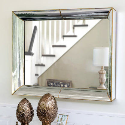 Decorative mirror with gold frame on a wall, reflecting a staircase and lamp.