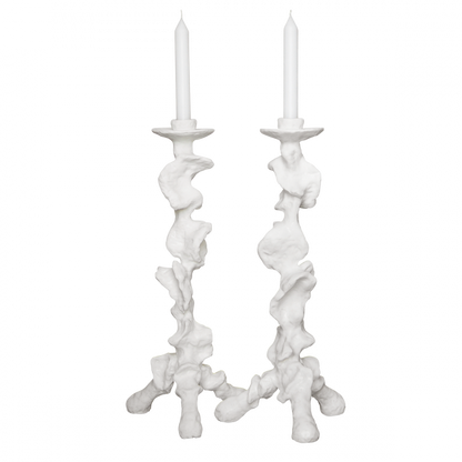 Two white candle holders with candles on a white background