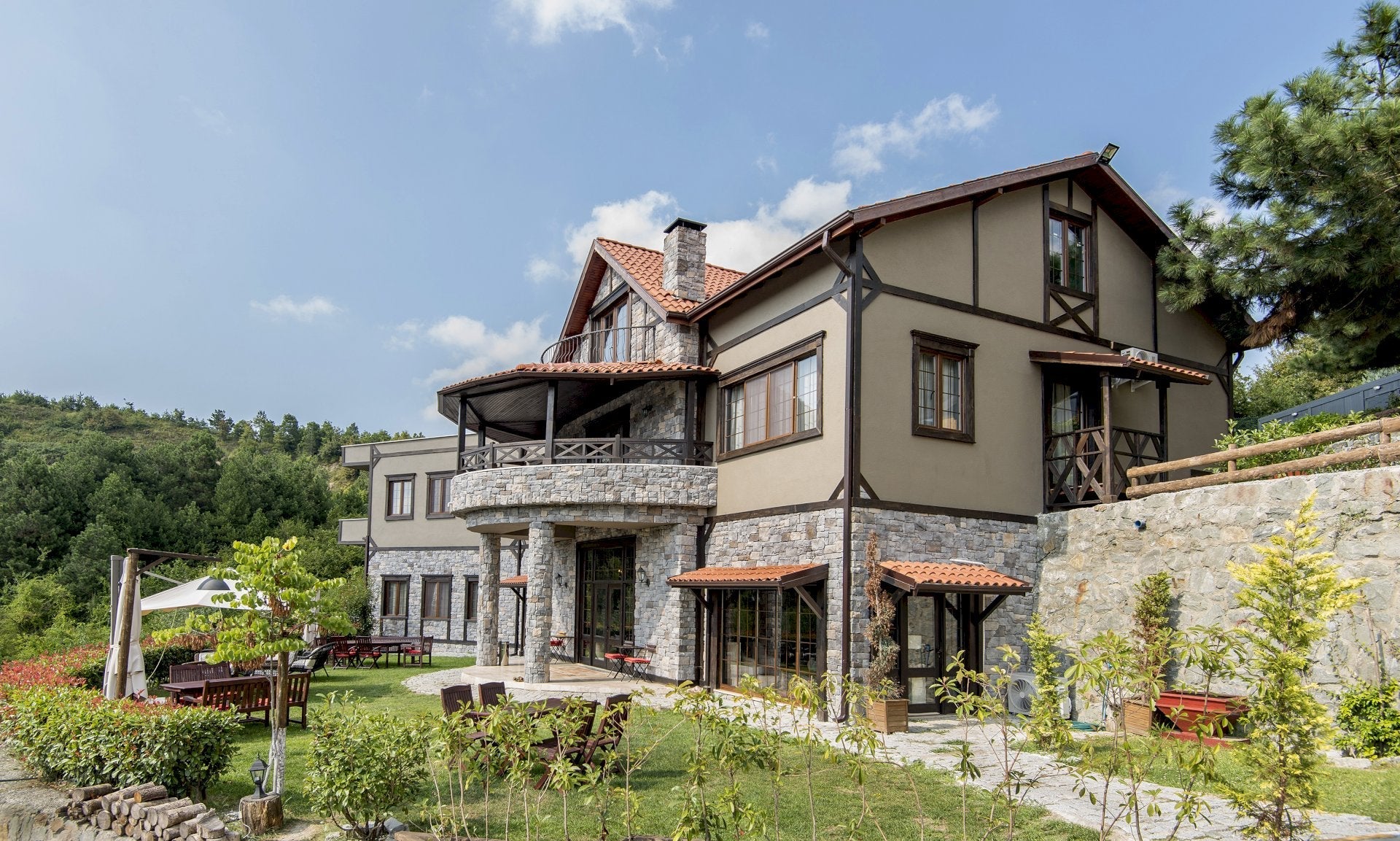 Large stone house with a garden and trees in the background