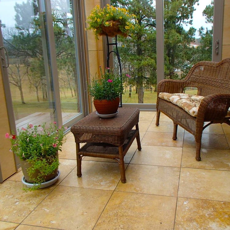 Wicker furniture set with potted plants on a tiled patio